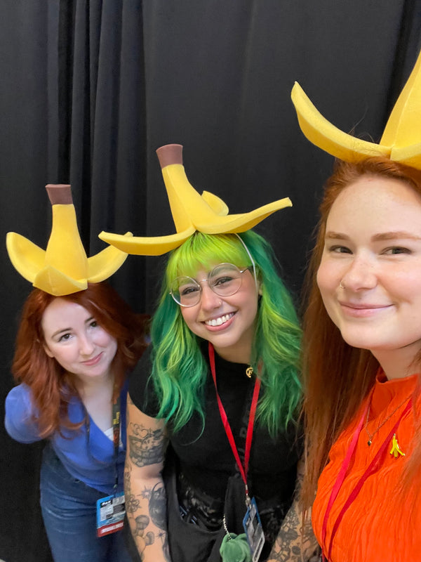 three women wearing foam banana hats