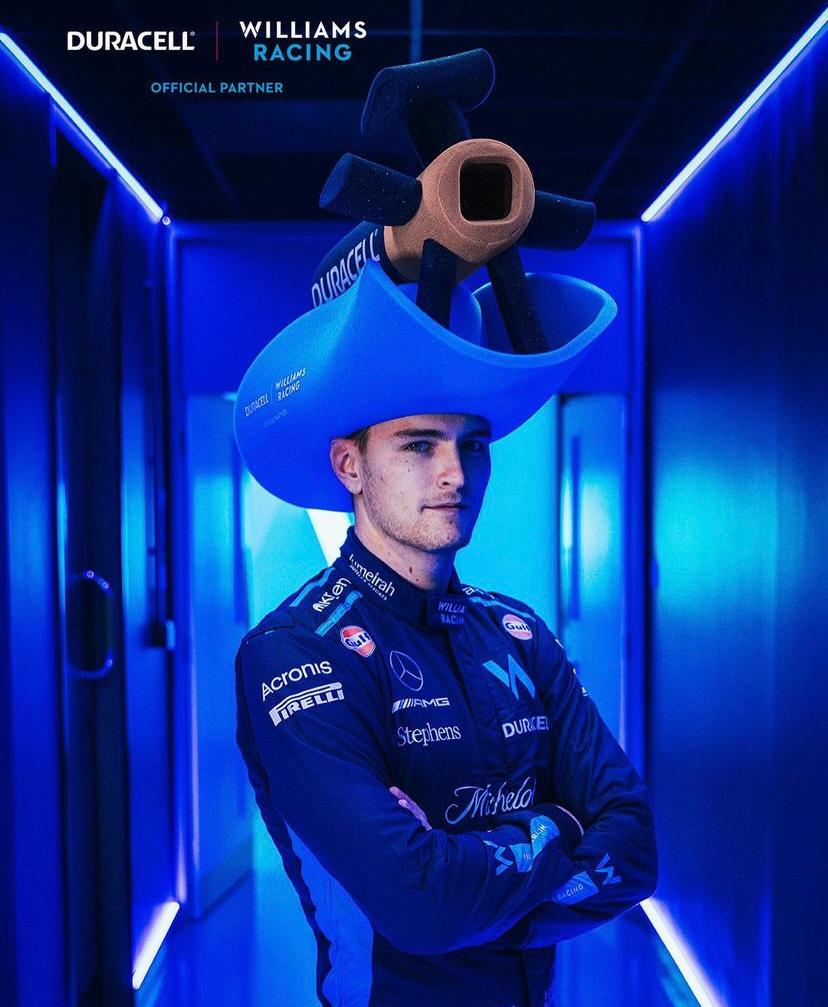 Man wearing a blue foam cowboy hat with a Duracell battery in foam atop the hat