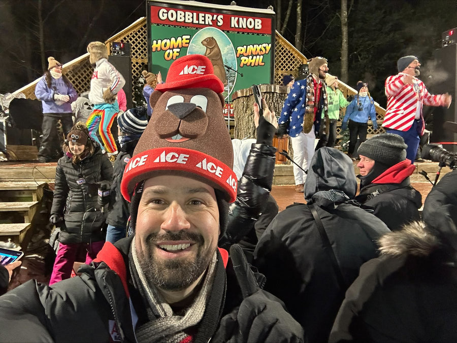 Fan wearing a custom Ace Hardware foam groundhog hat at Gobbler's Knob on Groundhog Day in Punxsutawney